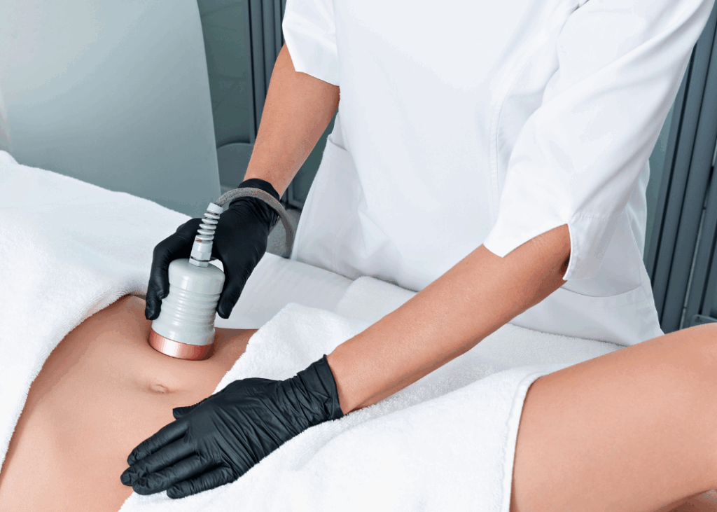 A woman receiving a laser treatment on her stomach in a clinical setting