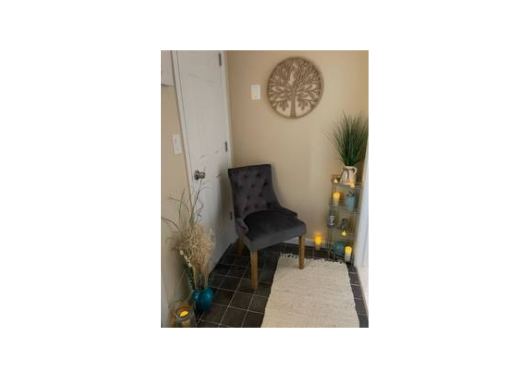 A chair positioned in a room featuring a door and a wall clock, creating a simple and functional interior space.